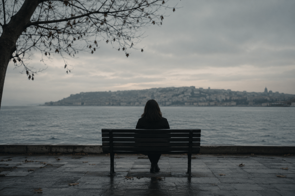 Joven mujer sentada en un muelle, en el atardecer de invierno